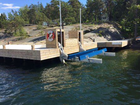 Brygga byggd på stolp-på-berg fundament. Båtlyft från Green Marine.