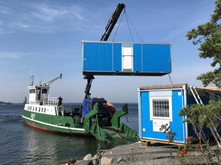 Arbetsfärjan Krut lossar en byggbod på Skarprunmarn vid Kanholmsfjärden.