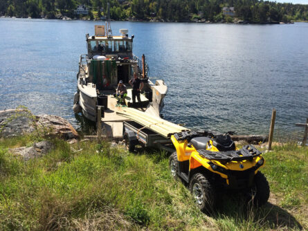 Leverans av byggmaterial med arbetsbåt, fyrhjuling och släp på Vårholma.